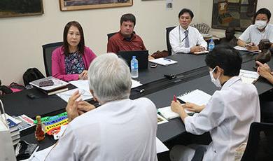 BSU和日本研究人员坐在会议桌旁.